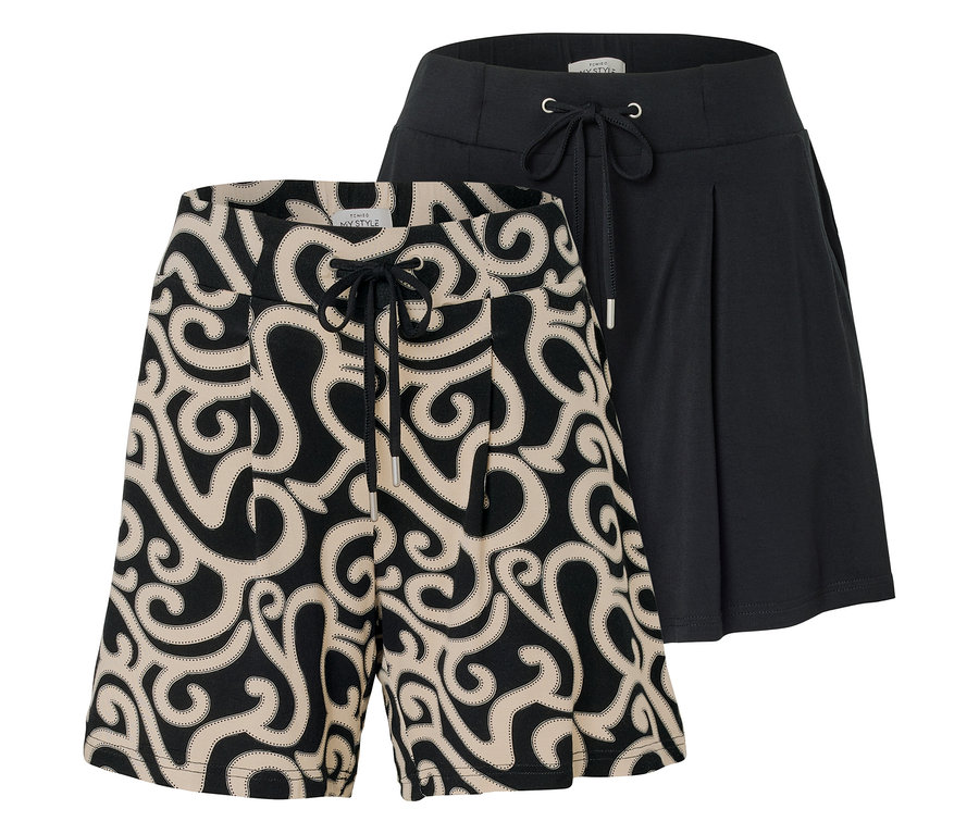 Zwei kurze Hosen sind zu sehen, eine mit einem beigen Wirbelmuster auf schwarzem Grund und eine schwarze Hose mit Kordelzug.