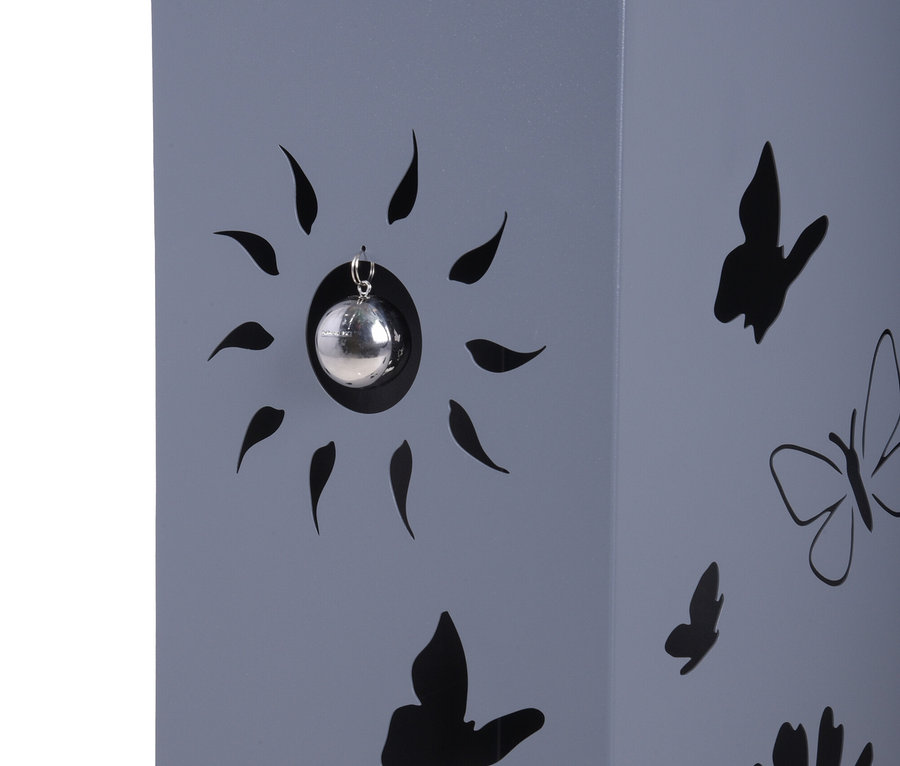 Nahaufnahme einer grauen Laterne mit Aussparungen in Form von Sonne, Schmetterlingen und Blumen.