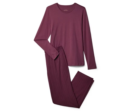 Burgunderfarbenes Pyjama-Set, bestehend aus einem langärmligen Oberteil und einer Hose mit Zickzackmuster, auf einem weißen Hintergrund.
