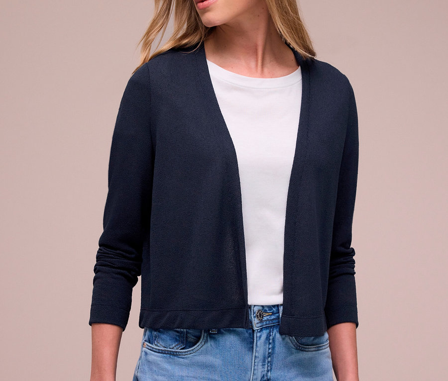 Frau trägt einen dunkelblauen Street One Cardigan, ein weißes T-Shirt und hellblaue Jeans.