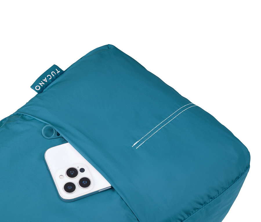 Ein weißes Smartphone steckt in der Tasche eines türkisfarbenen Tucano-Kissens.