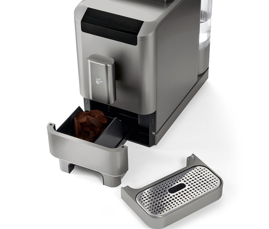 Detailaufnahme des »Esperto2 Caffè« Kaffeevollautomaten in Titanium Silver mit entnommenem Kaffeesatzbehälter und Tropfschale.