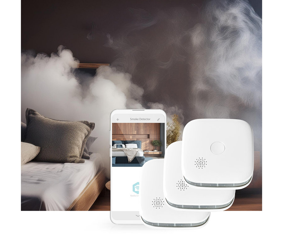 Ein mit Rauch gefülltes Schlafzimmer, ein Smartphone mit einer Rauchmelder-App, die ein Schlafzimmer zeigt, und drei weiße quadratische Rauchmelder im Vordergrund.