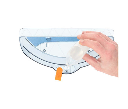 Hand gießt Flüssigkeit aus einem Messbecher in einen transparenten Wassertank mit blauem Filter und orangefarbener Lasche.