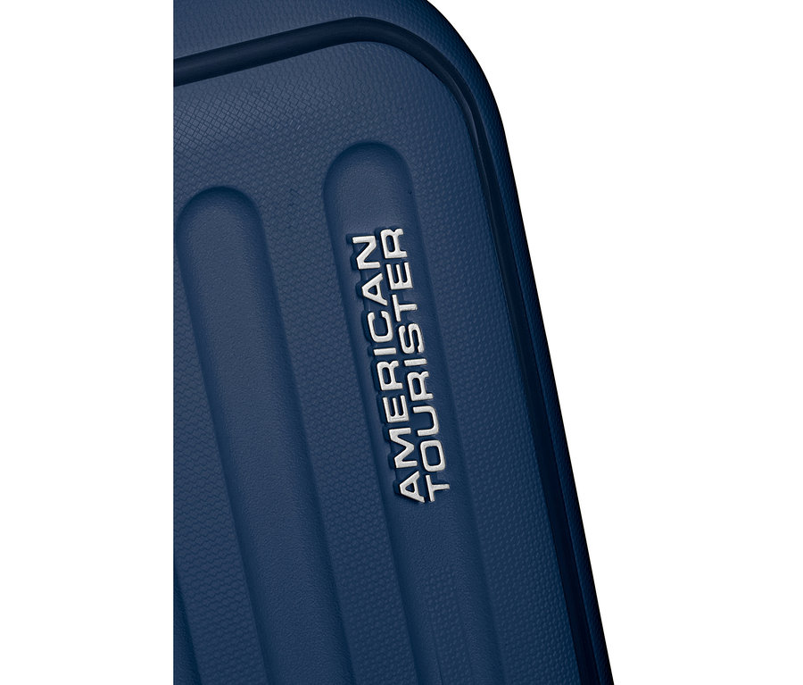 Nahaufnahme eines großen, marineblauen American Tourister Rejoy Spinner Koffers mit dem silbernen AMERICAN TOURISTER Logo auf der gerippten Oberfläche.