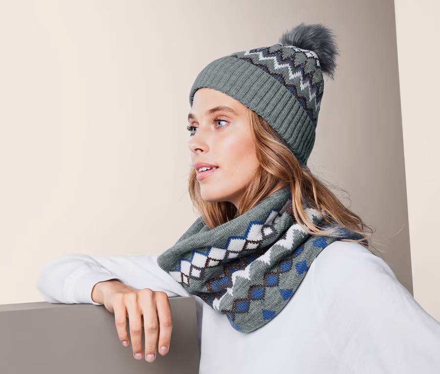 Frau mit Strickmütze und Schal mit Norwegermuster.