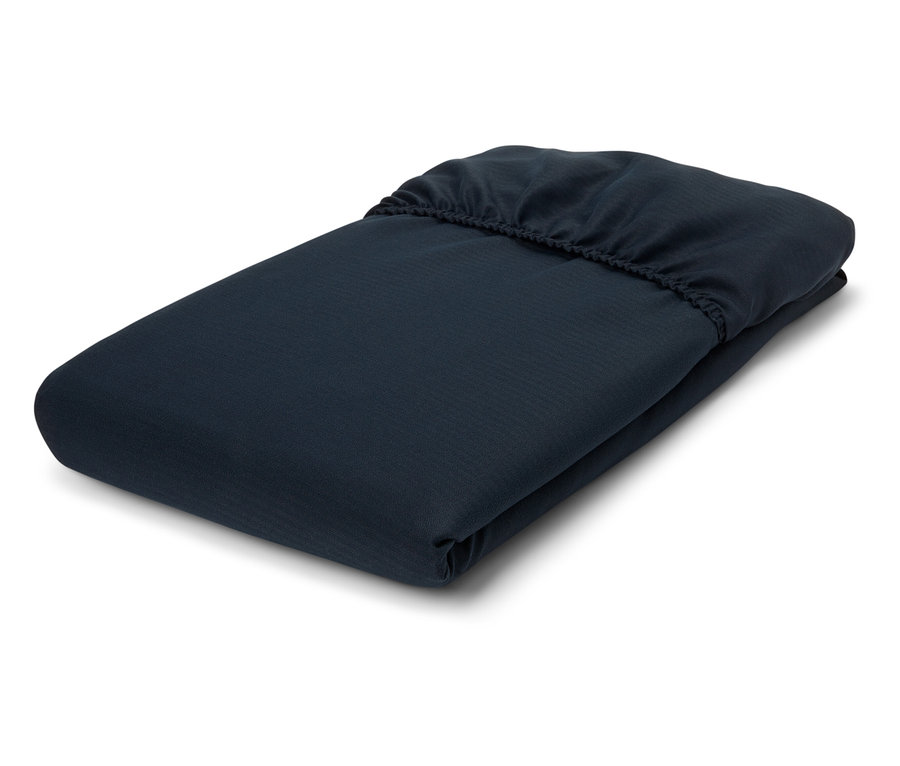 Gefaltetes marineblaues Spannbettlaken auf weißem Hintergrund.