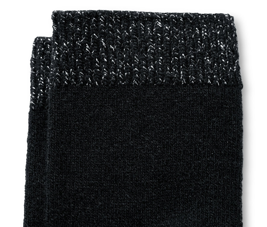 Detailansicht von zwei Paar schwarzen Socken mit Wollanteil und silbernem Saum.