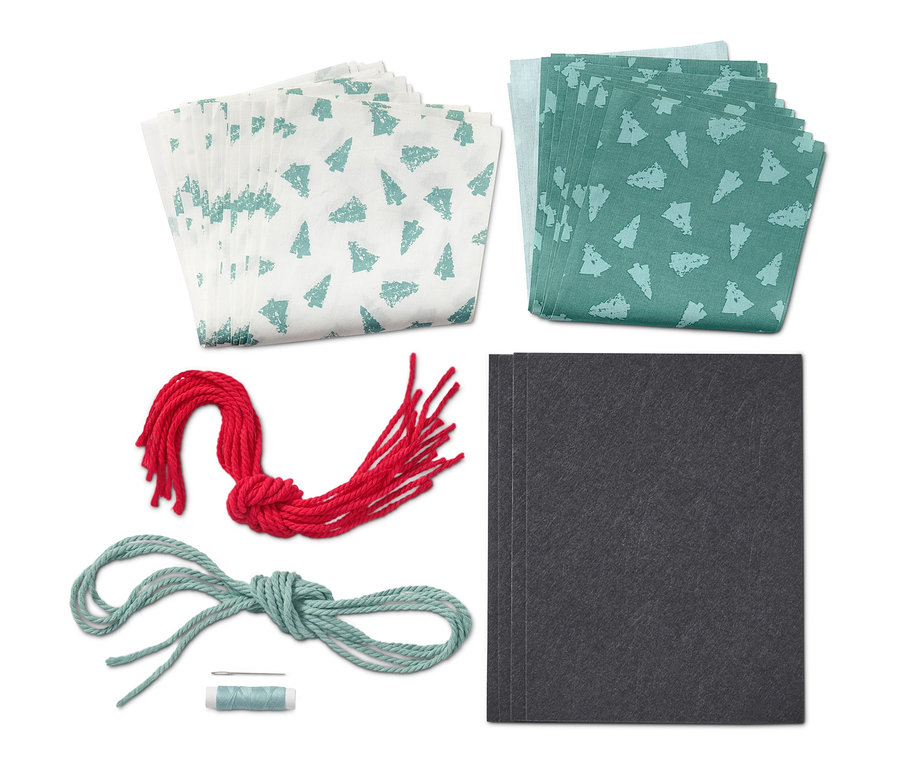 Näh-Set »Stoff-Adventskalender« mit weißen und grünen Stoffen, roter und blauer Schnur und schwarzen Karten.