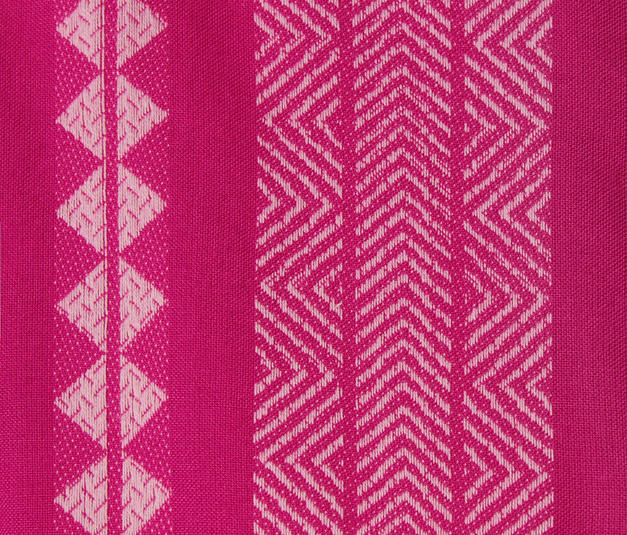 Detailansicht eines pinkfarbenen Webkleides mit Ikat-Muster.