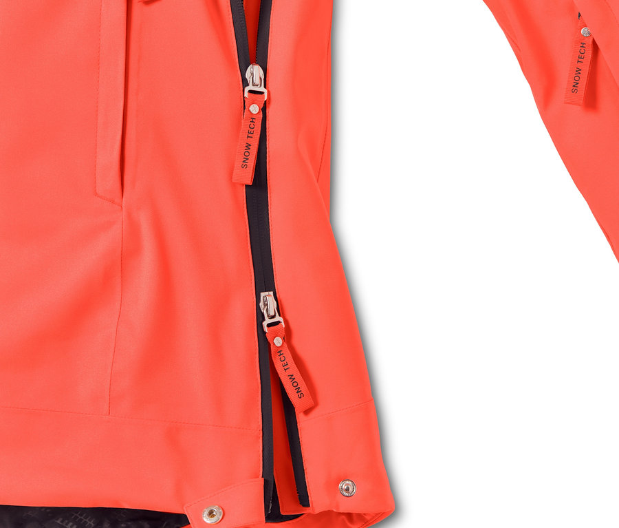 Detail einer neonorangefarbenen Halfzip-Skijacke mit schwarzen Reißverschlüssen.