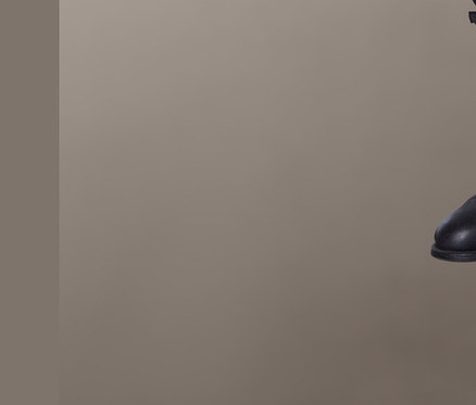 Blonde Frau sitzt und trägt ein bedrucktes Blusenshirt.