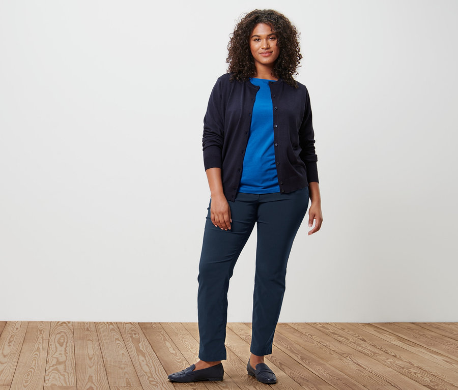 Eine Frau trägt einen Feinstrick-Cardigan, ein kobaltblaues Shirt mit 3/4-Arm und eine dunkelblaue Bengalin-Hose.