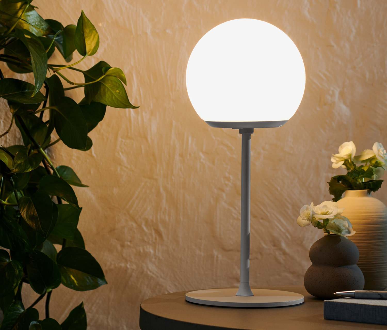 Eine leuchtende LED-Akku-Tischleuchte steht auf einem Tisch.