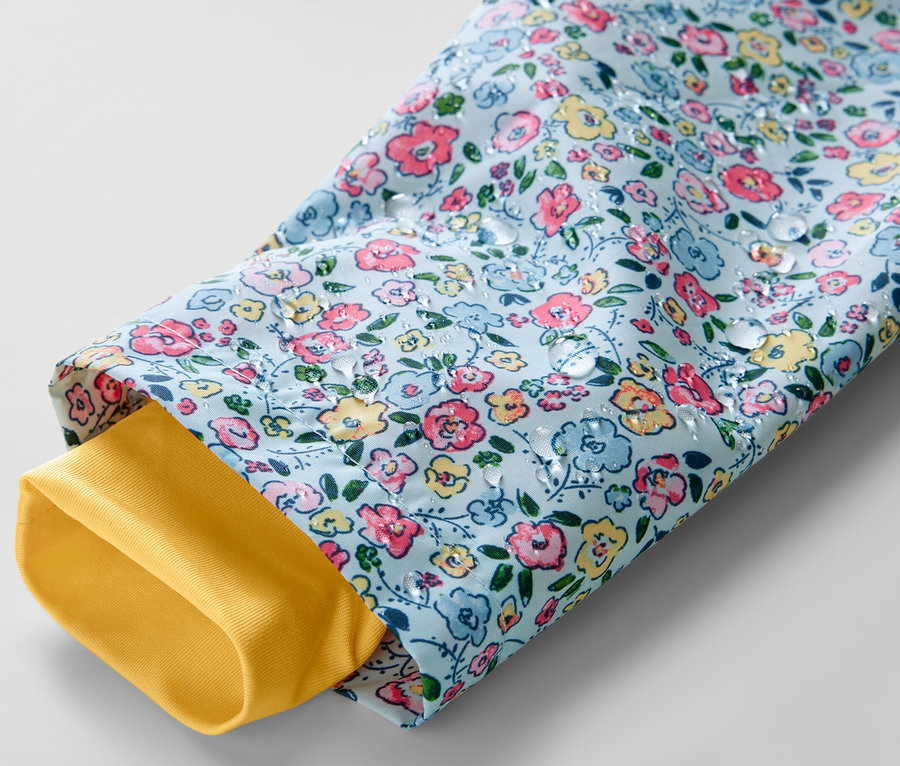 Detailaufnahme einer Kinder-Regenjacke mit Blumenmuster und gelbem Ärmelfutter.