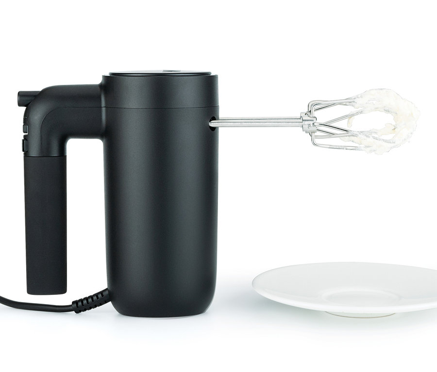Schwarzer WILFA Handmixer SMOOTH-MIX »HM1B-50« mit Edelstahl-Rührbesen und weißer Masse an den Rührbesen neben einem weißen Teller.