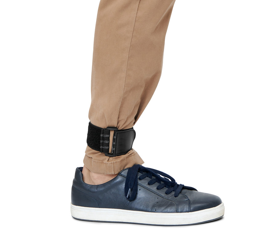 Hose, die mit 6 elastischen Befestigungsgurten über dem Knöchel und einem blauen Schuh zusammengehalten wird.