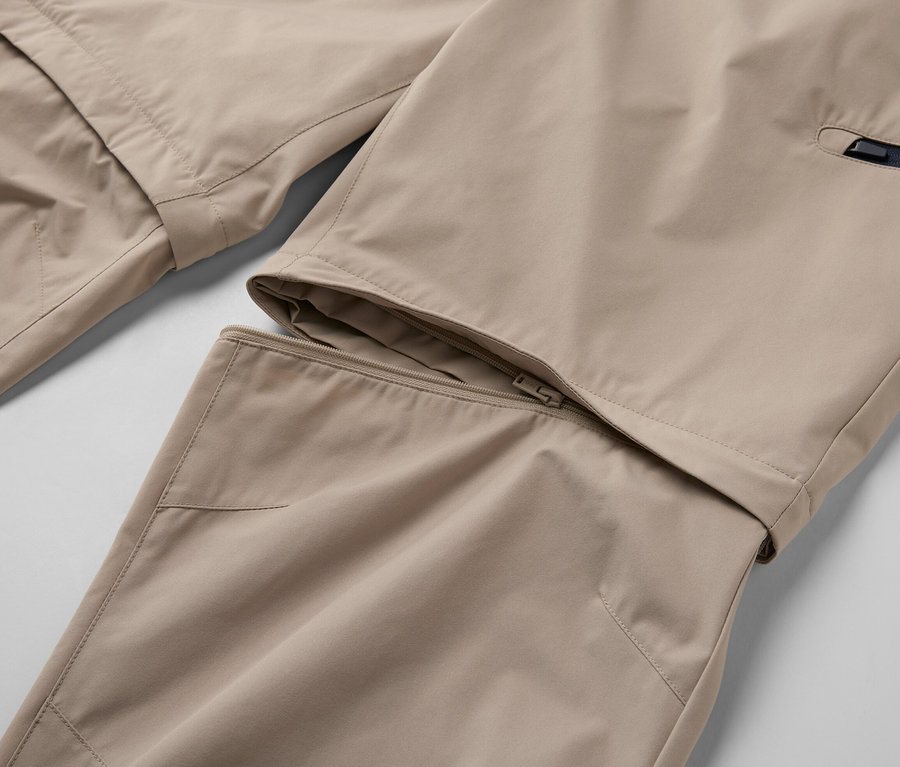 Detailaufnahme einer beigen 2-in-1-Funktionshose mit Reißverschluss.