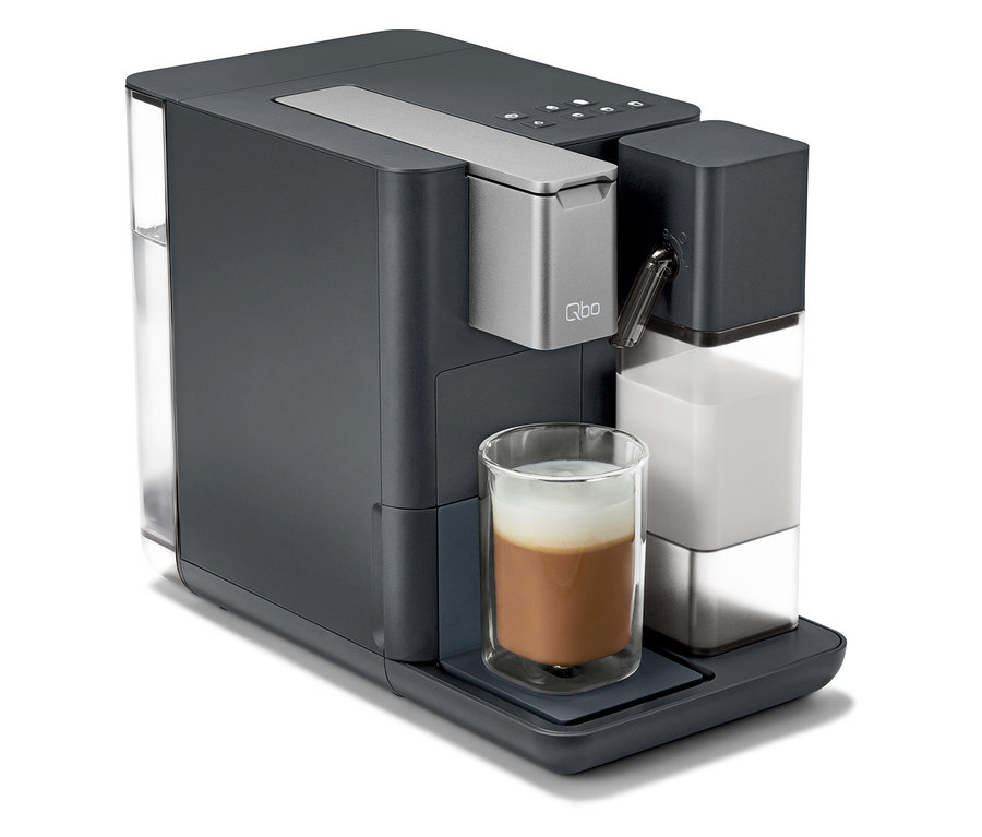 Graue Qbo MILK MASTER Kaffeemaschine mit in ein Glas gegossener Milch.