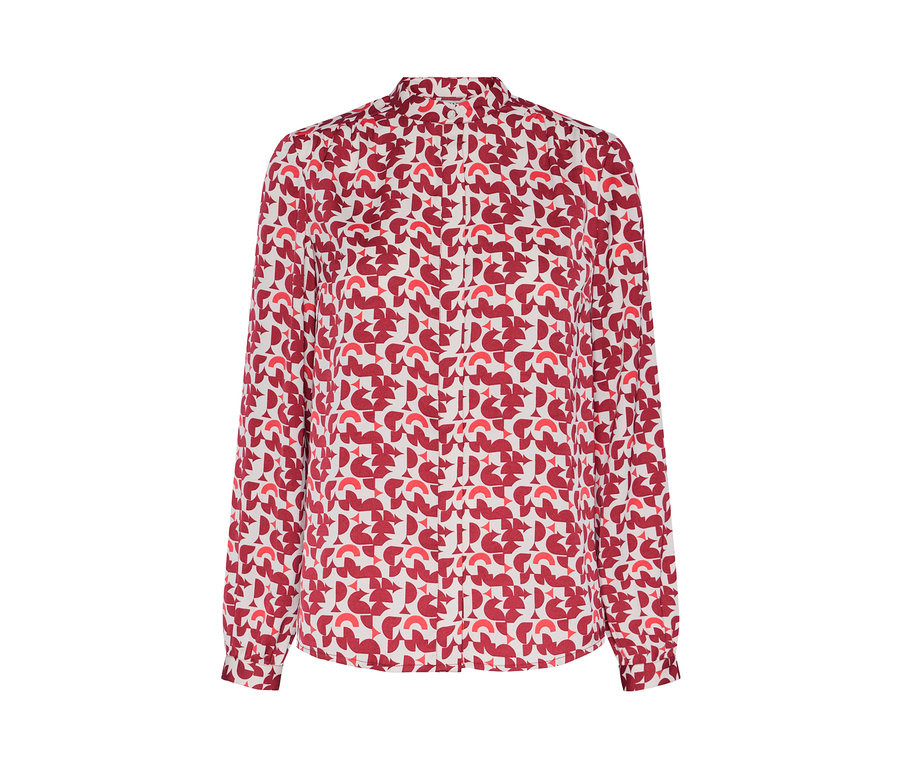Detail einer bedruckten Bluse mit rotem geometrischen Muster.