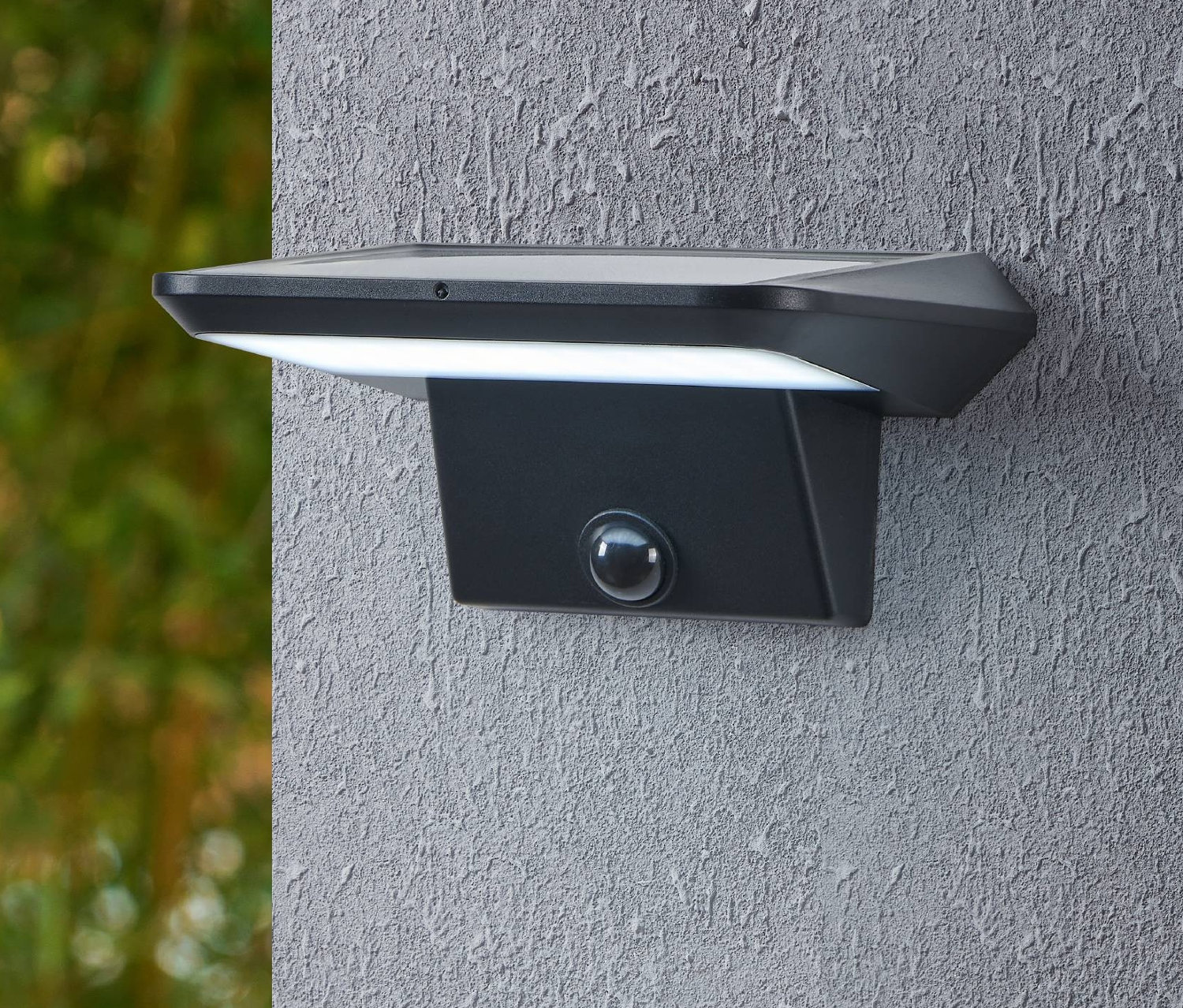 Schwarze Eglo Solar-Wandleuchte »Porrassa« an einer strukturierten Wand befestigt.