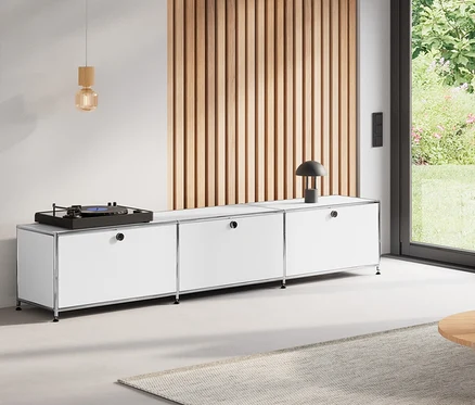 Wohnzimmer mit rundem Couchtisch, 80 cm, Lowboard Metall »CN3« mit 3 weißen Klappenfächern, Klappenergänzungs-Set Metall »CN3«, orange, und Hängeleuchte aus Holz.