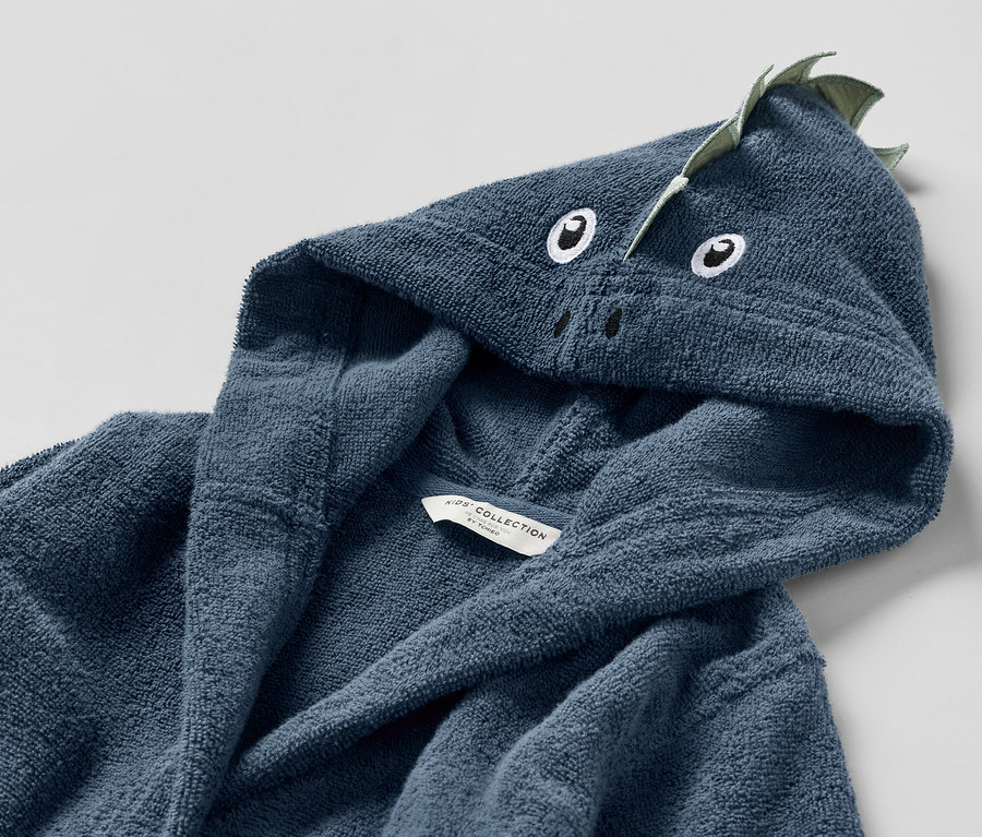 Detailaufnahme eines blauen Kinder-Bademantels mit Drachen-Kapuze.