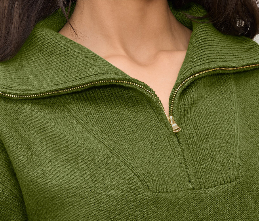 Detailaufnahme eines olivgrünen Damenpullovers mit Reißverschluss.