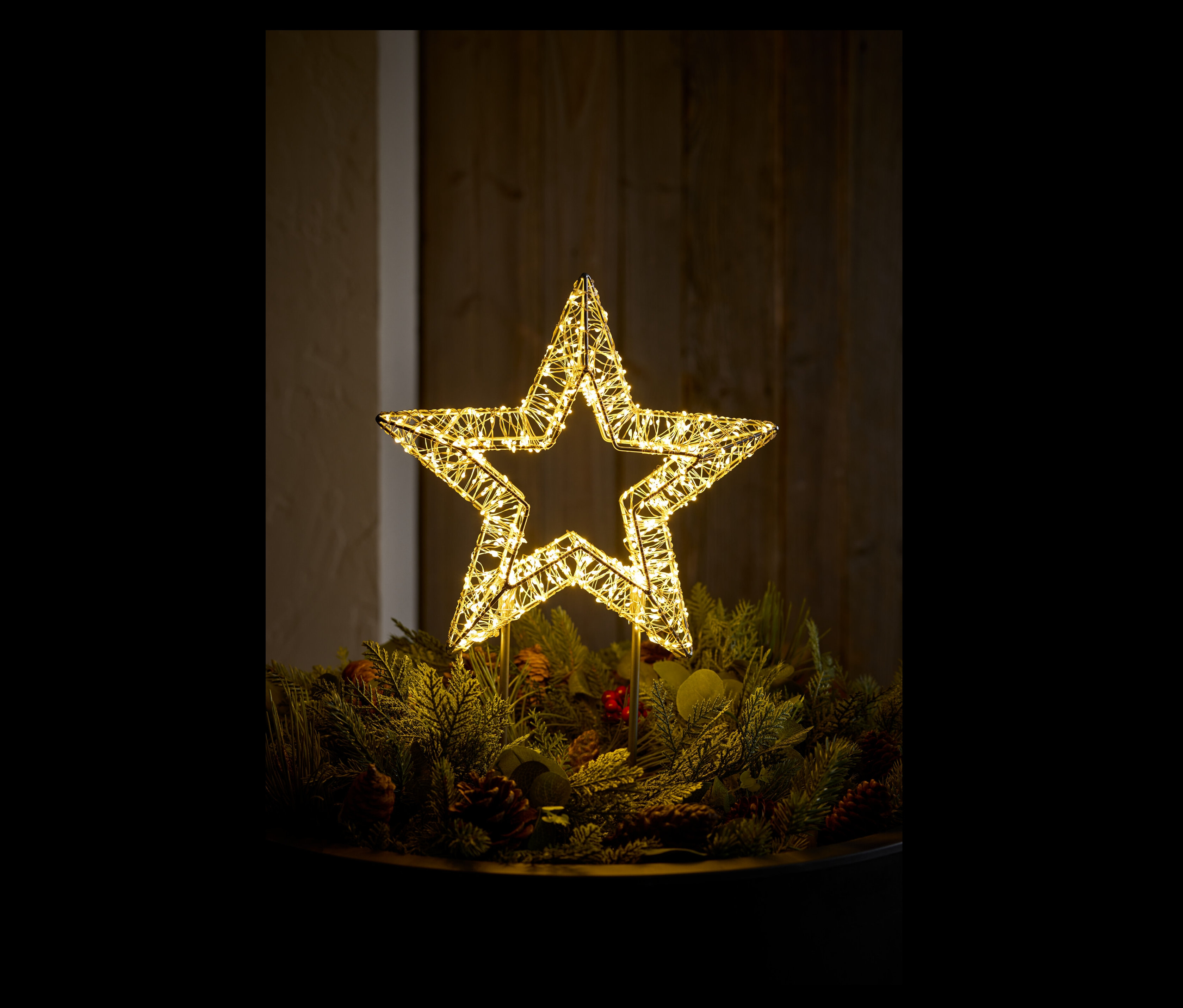 Ein beleuchteter Stern auf einem Weihnachtskranz.