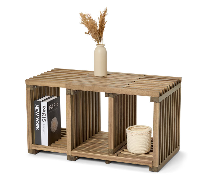 Holzregal mit den Büchern „New York“ und „Paris“, einer Vase und einem geflochtenen Korb.