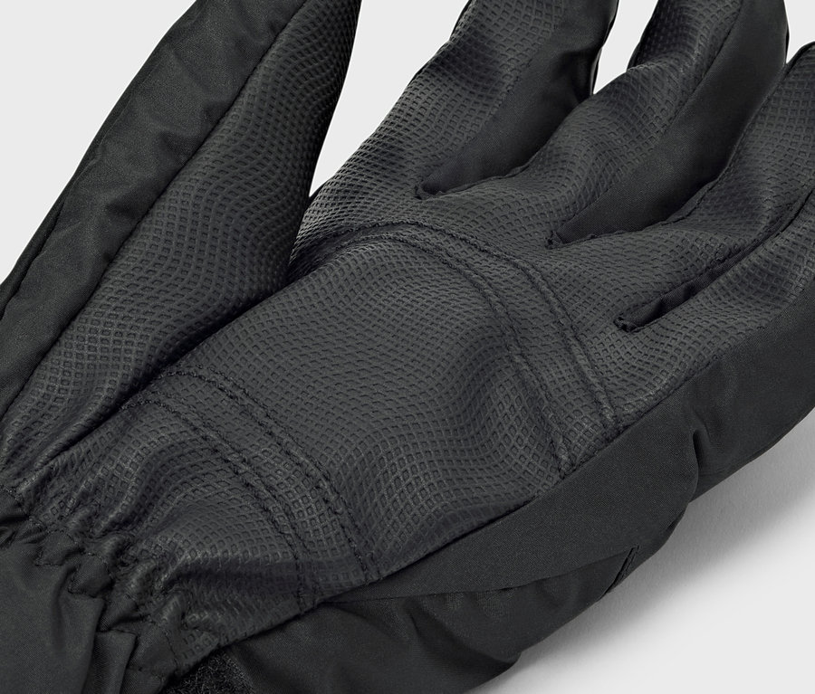 Detailaufnahme eines schwarzen Handschuhs mit strukturierter Handfläche.