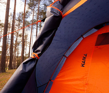 Detailansicht ins Innere des Tambu 4-Personen-Kuppelzelts »HAIKA 4« mit orangefarbener Wand und blauem Dach.