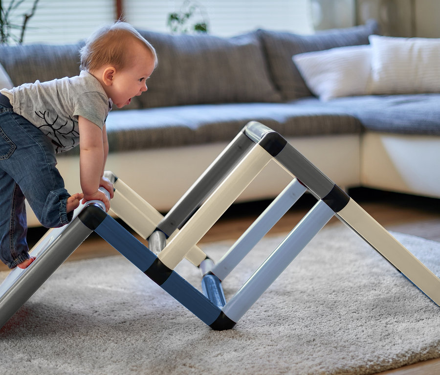 Ein Kind klettert auf ein Quadro-Home-BEGINNER-Set im Wohnzimmer.