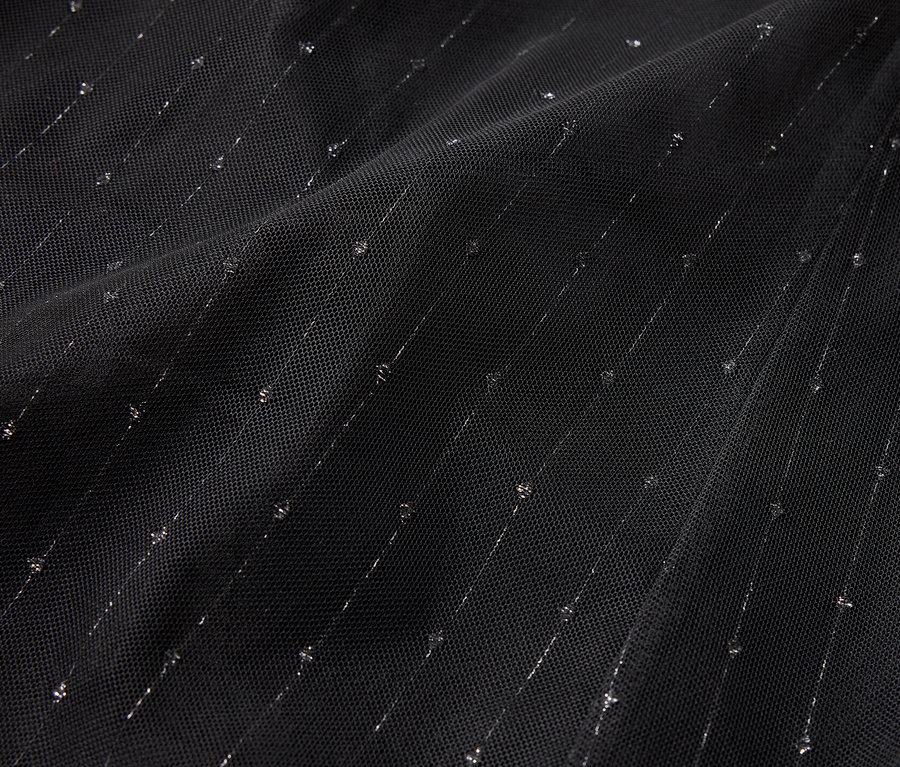 Detailaufnahme eines schwarzen Stoffes mit diagonalen silbernen Streifen und Punkten.