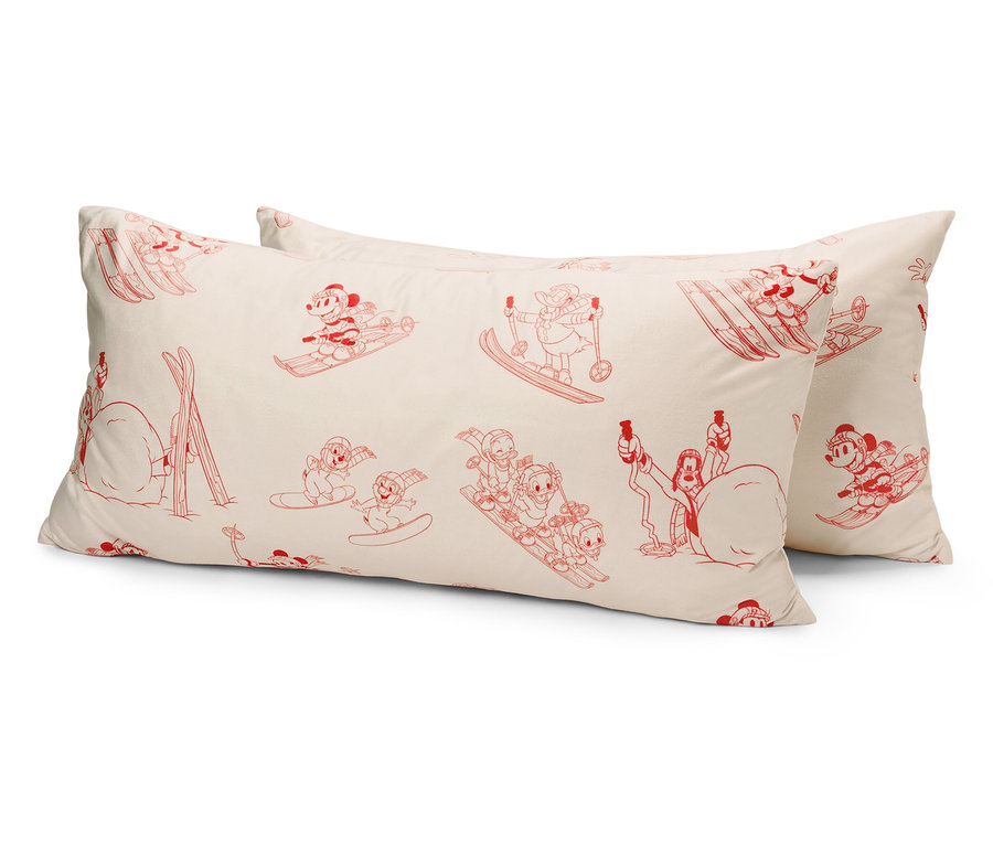 Zwei weiße Kissen mit roten Zeichentrickfiguren von Ski fahrenden Mäusen.