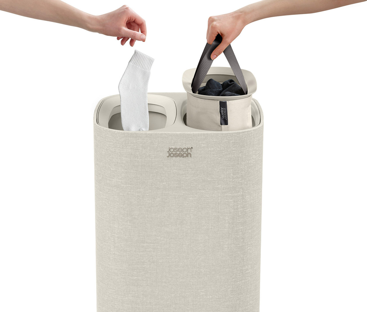 Eine Hand legt eine Socke in den Joseph Joseph »Tota«, 60 l Wäschesortierer, während eine andere Hand einen Wäschesack hält.