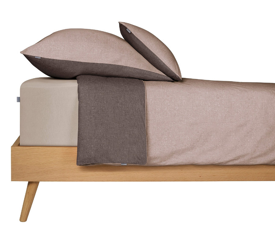 Bettwäsche-Set mit zwei SCHIESSER Renforcé-Kissenbezügen »Doubleface«, 40 x 80 cm, in Taupe/Dunkelgrau auf einem Holzbett.