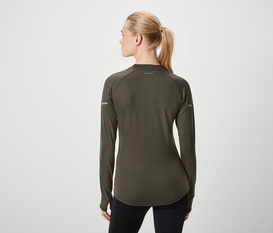 Rückansicht einer Frau mit blonden, zu einem Pferdeschwanz zusammengebundenen Haaren, die ein olivgrünes Langarmshirt und schwarze Leggings trägt.