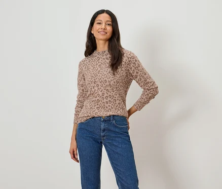 Frau trägt einen hellbraunen Pullover mit Leopardenmuster und blaue Jeans.
