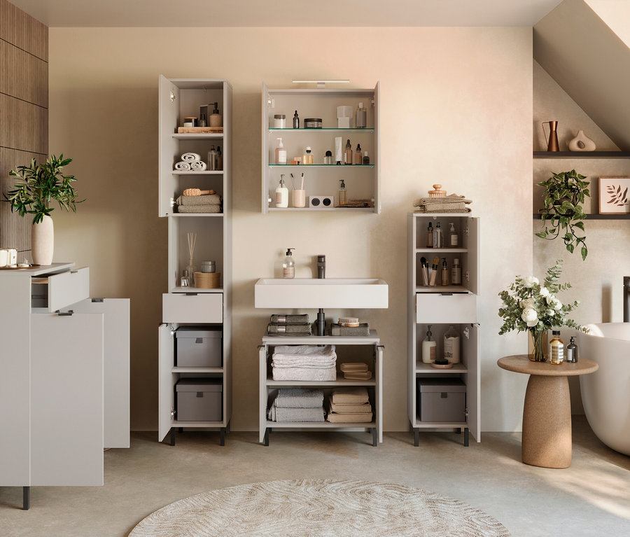 Badezimmer mit Waschbecken, Schränken und Badewanne.