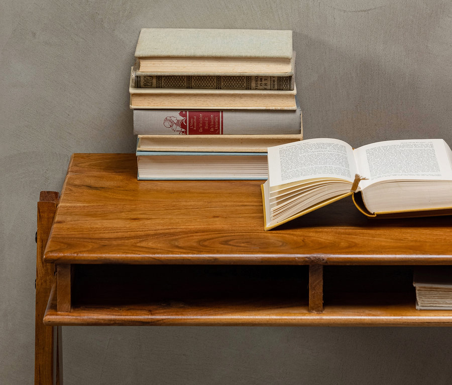 Auf einem braunen BePureHome Schreibtisch »Compartment« liegen ein offenes Buch und ein Bücherstapel.