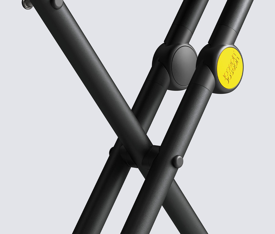 Detailaufnahme eines schwarzen Klappständers mit gelbem Knopf vor grauem Hintergrund.