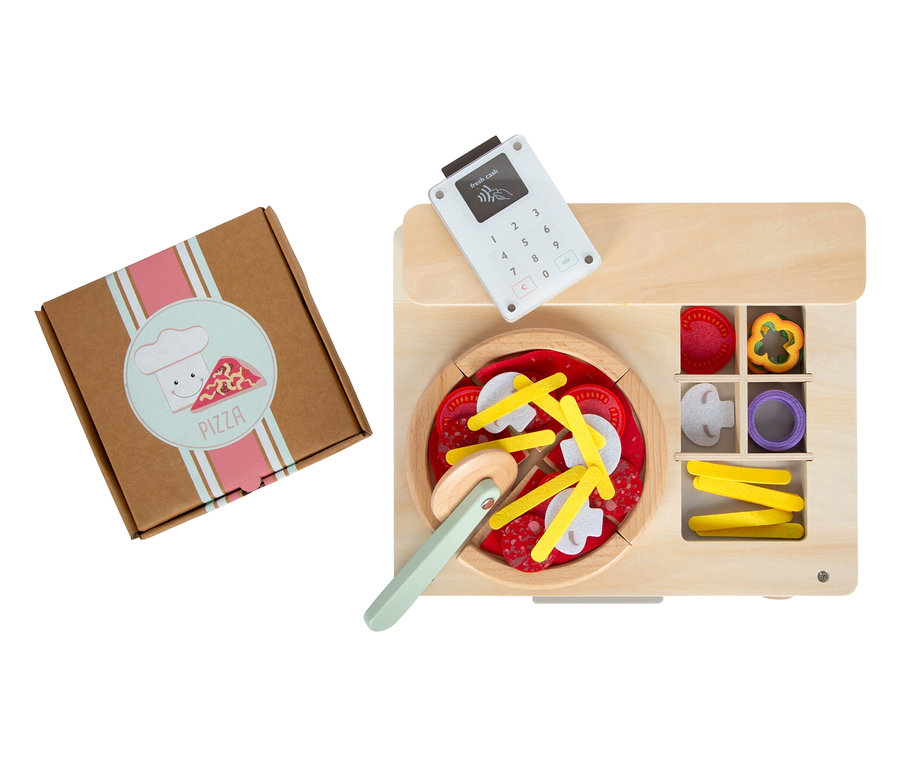 Pizza in Schachtel und hölzerner Spielzeug-Tresen mit Pizza, Pizzaschneider und Fächern mit Zutaten.