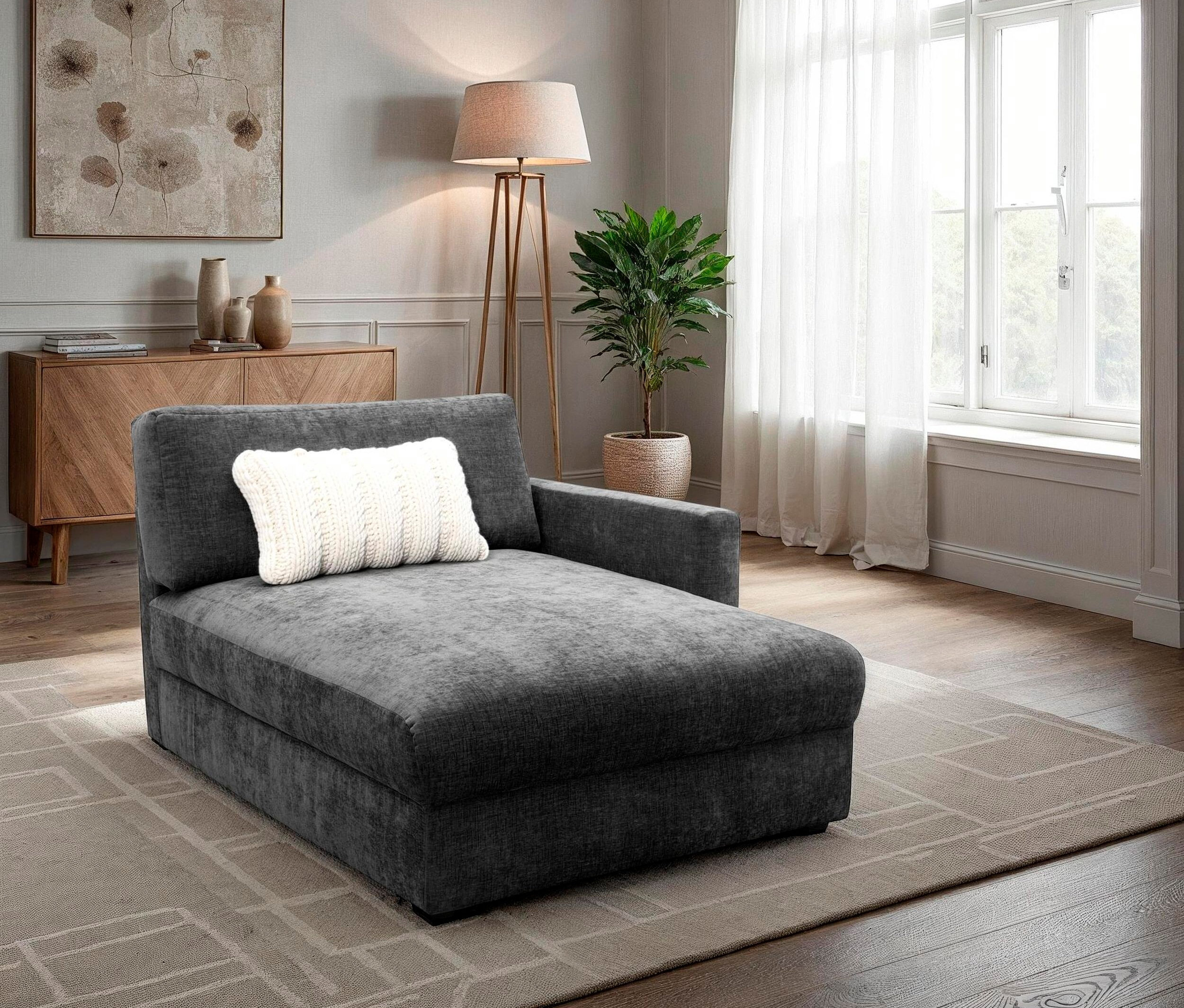 Graue Liege mit weißem Kissen in einem Wohnzimmer.