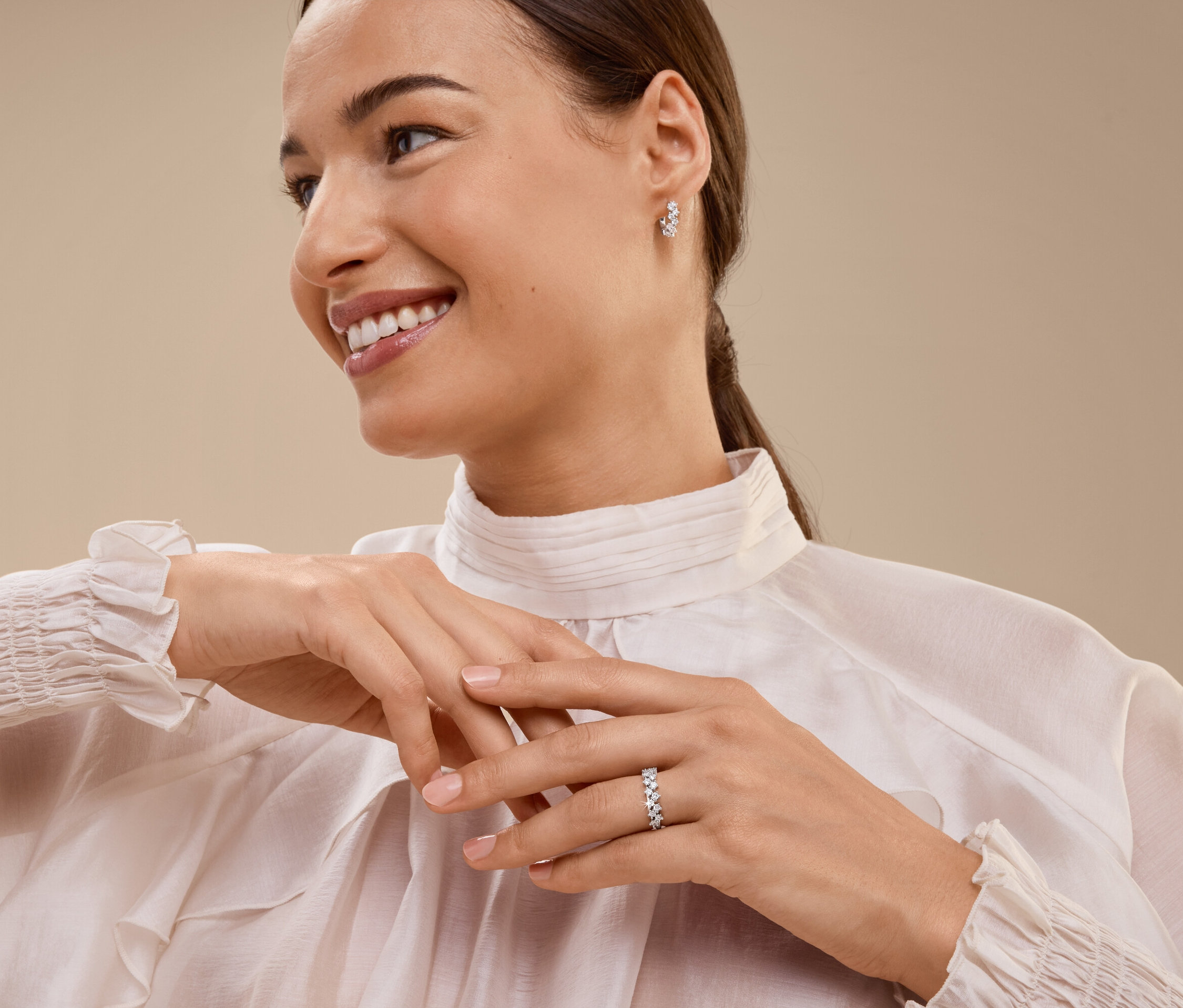 Lächelnde Frau mit Ring und Ohrringen.