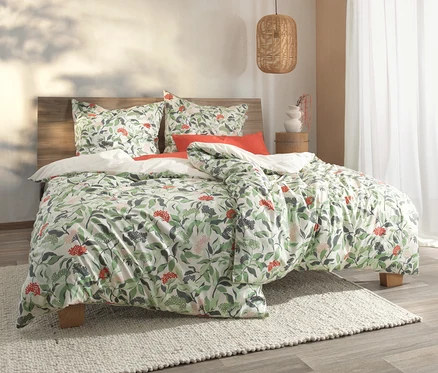 Bett mit Bettwäsche mit Blatt- und roten Beerenmuster. Sichtbar ist SCHÖNER WOHNEN-Kollektion Bettwäsche.