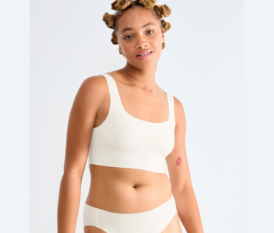 Frau trägt ein Sloggi ZERO Feel 2.0 Top in Seidenweiß und Unterhose.