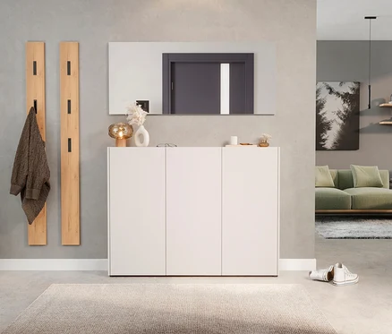 Flur mit weißem Schuhschrank unter rechteckigem Spiegel, zwei Holzgarderobenpaneelen und beigem Teppich.