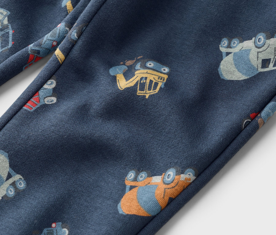 Detailansicht einer marineblauen Hose mit einem Allover-Muster aus Bauwagen.