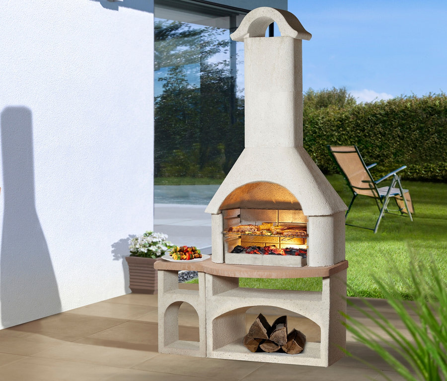 Buschbeck Gartengrillkamin »Bozen« steht auf einer Terrasse, Grillgut liegt auf dem Rost.